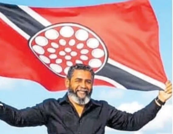 Jesse Peter Andrews holding up a Trinidad and Tobago flag with a tenor pan at its centre